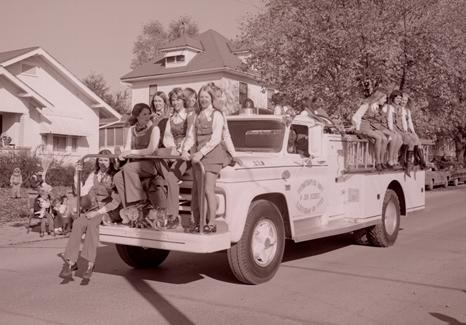 A group of Northwest sorority sisters ride on a Maryville fire truck during the 1973 Homecoming Parade to show their school spirit.